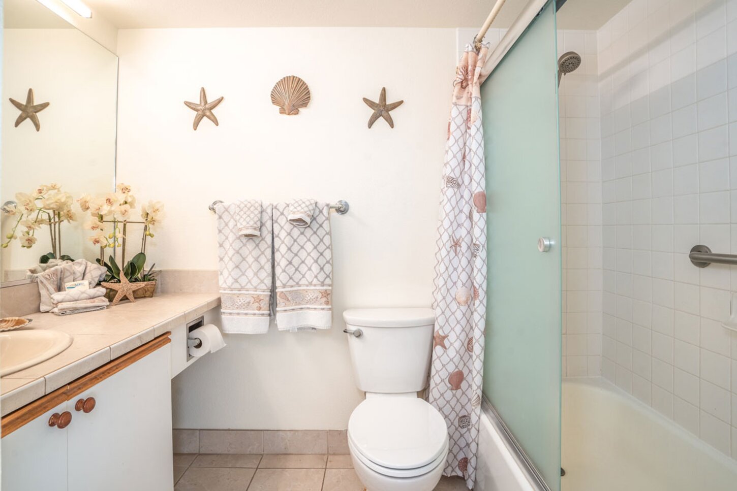 Upgraded Master bathroom with tiled counter top and shower over tub.  Even grab bars