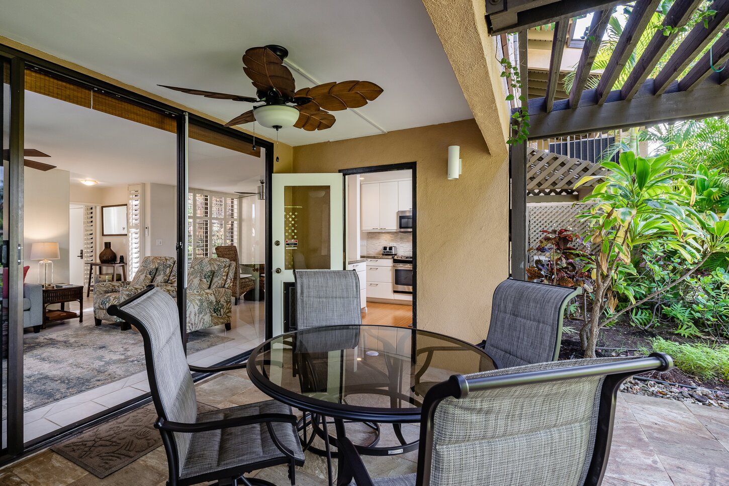 The living room and kitchen open onto the main lanai and lush private gardens.