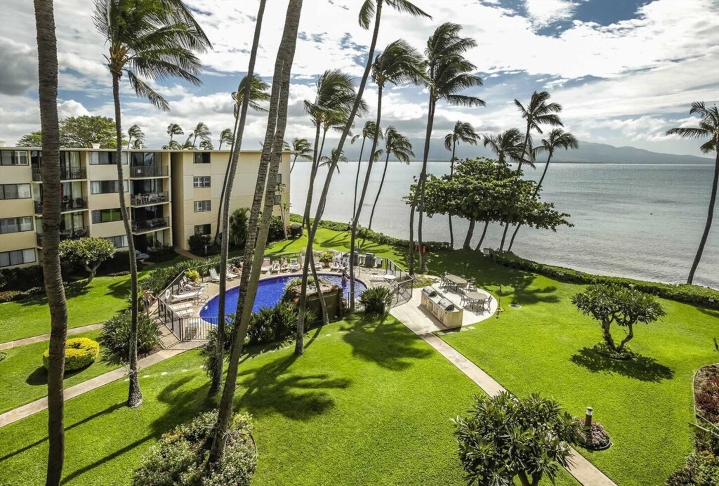Manicured grounds with heated pool, loungers, chairs, outdoor dining and gas grills