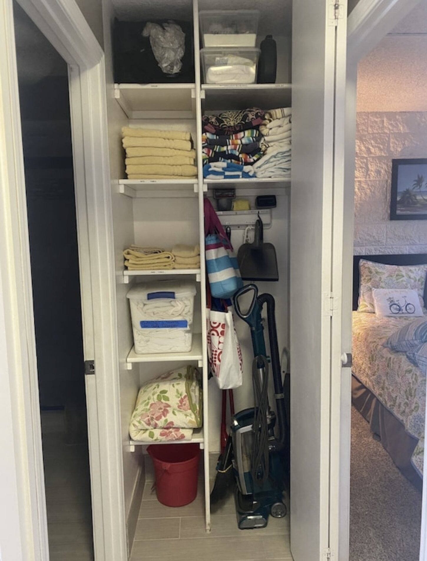 Hall closet stocked with beach towels, cooler, re-useable grocery bags, extra towels and linens