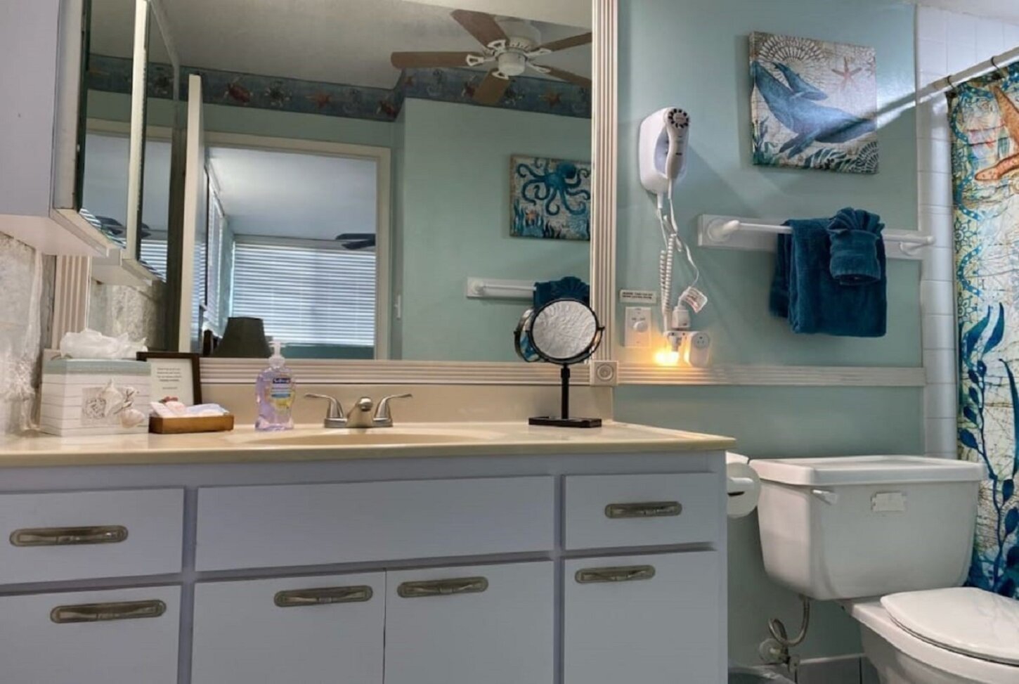 Hair dryer, make-up mirror, designer towels and rugs, toiletries & ceiling fan.