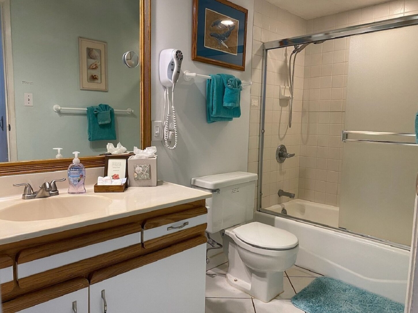 2nd bathroom has ceiling fan, tub for kids with hand-held shower head, toiletries, and hair dryer