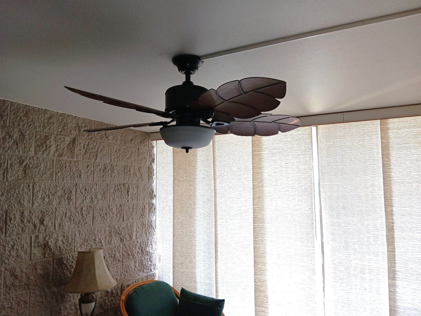 New designer ceiling fan in living room and dining area with wide wood blades to move the air.